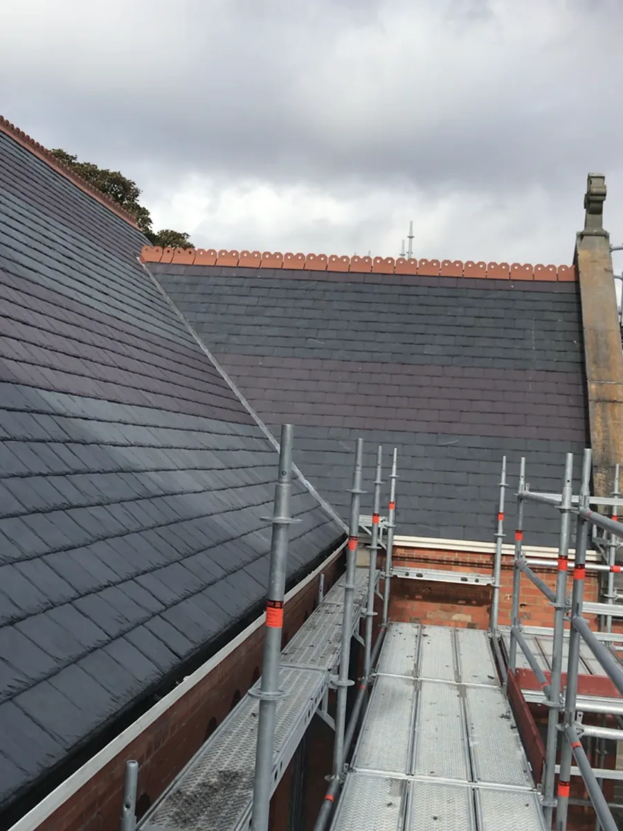 Roofing work shown from scaffolding beside a tiled roof